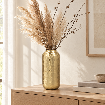 Gold hammered barrel vase with pampas on an oak sideboard